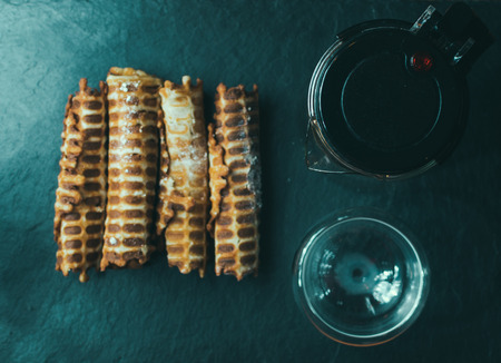 Home tube waffles and kettle with cup on the tableの写真素材