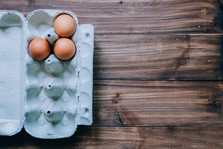 Brown eggs in box on wood table