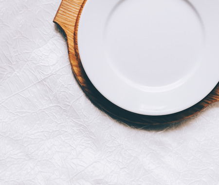 Empty white plate on home wooden tableの写真素材