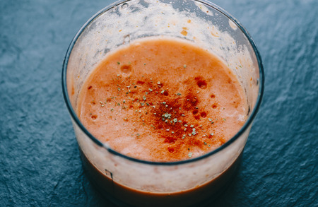 Tomato soup with spice on black stone backgrpundの写真素材