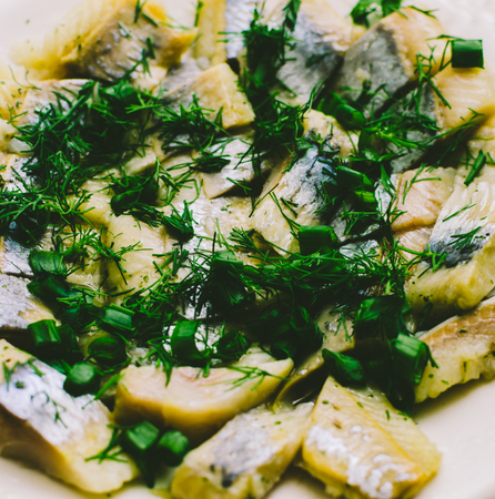 Fish and green on white plate on home kitchen tableの写真素材