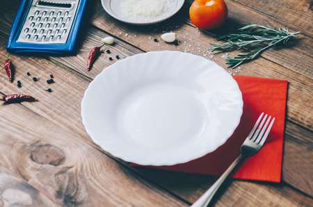 Empty white plate on the home wooden kitchen tableの写真素材