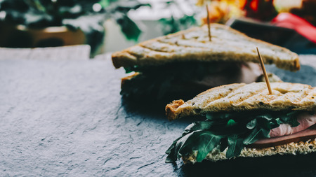 Two sandwiches on black stone background on kitchen tableの写真素材