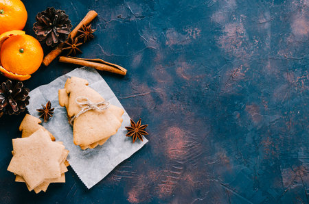 Christmas cookies and oranges mandarins on dark background