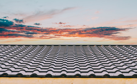 Red metal corrugated roof sheets and skyの写真素材