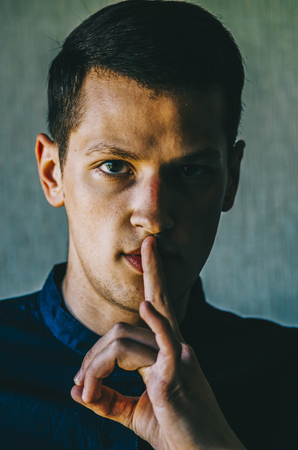 Attractive man with finger on lips making silence gesture. Shh!!!の写真素材