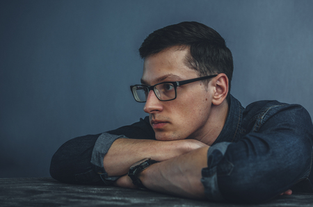 Portrait of the young man in glasses in studio roomの写真素材