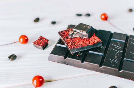 Dark chocolate with berry on white wood table