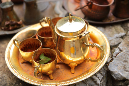 Antique copper teapot and cup of tea on stone backgroundの写真素材