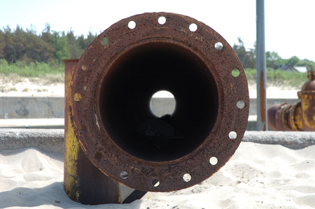 Old rusty pipe on the beachの写真素材