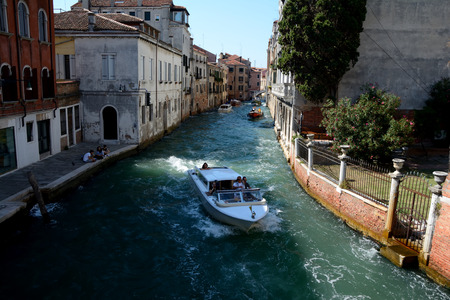 Venice, Italy - September 9, 2016: Boat on canal in Venice, Italy. Unidentified people visible.のeditorial素材