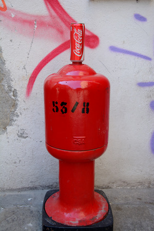 Venice, Italy - September 9, 2016: Coca Cola can standing on top of red hydrant.のeditorial素材