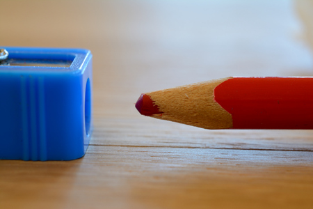 Coloured red pencil and sharpener on wooden table. Shallow depth of field.の写真素材