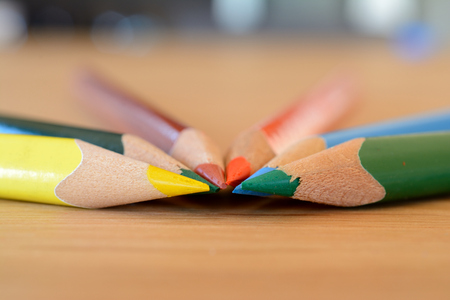 Coloured pencils on wooden table closeup. Shallow depth of field.の写真素材