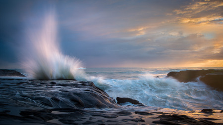 Waves splash against the rocks at west coast of Auckland New Zealandの写真素材