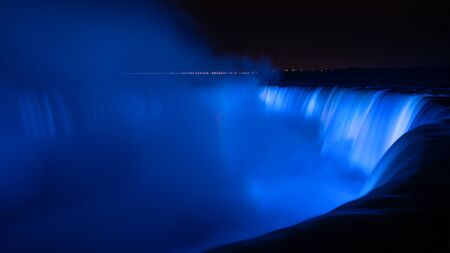 Niagara Falls illuminated in glowing blue coloursの写真素材