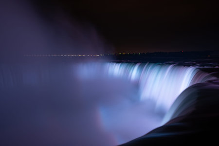 Niagara Falls illuminated in glowing colours at night