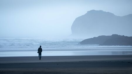 Walking on the Piha beach in the morning mistの写真素材