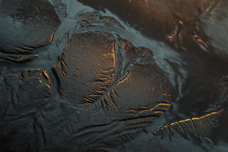 Tide goes out and leaves a beautiful tributary pattern in the sand at sunriseの写真素材