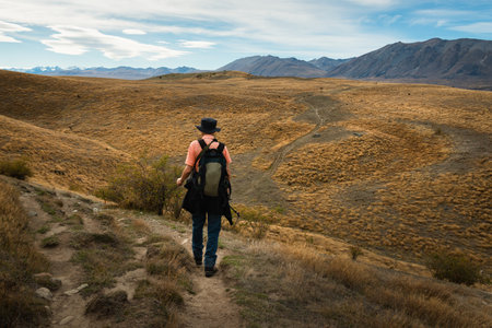 Tourist walking on the rolling hills of Lake Wanaka Peninsula Walkway, South Islandの写真素材
