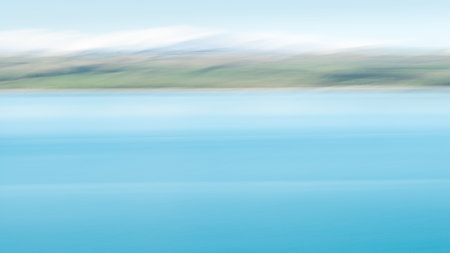 Abstract image of turquoise colours of Lake Pukaki with snow-capped mountains in the distance. Image...