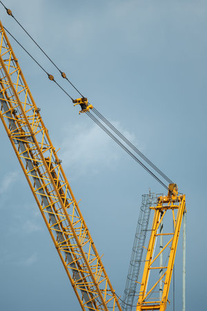 Industrial construction crane against the moody sky. Vertical format.