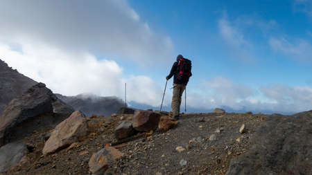 Hiking the steep scree terrain to the Red Crater on Tongariro Alpine Crossing. New Zealand.の写真素材