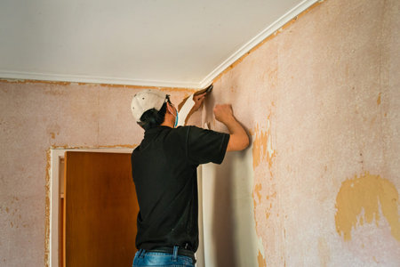 Man removing wallpaper inside an old houseの写真素材