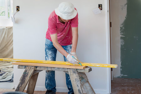 Builder marking the line on wood with pencil. Home renovation project.の写真素材