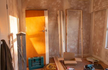 Doors and door frames leaning on the wall. Ladder and tools lying around the room. Home refurbishment project. Auckland.の写真素材