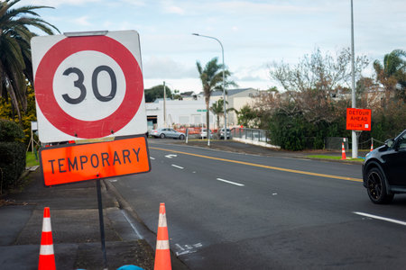 Temporary 30km speed limit sign and Detour Ahead sign by roadside. Roadworks on Auckland roads.の写真素材