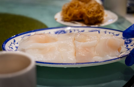 Hand holding Yumcha dish on table. Dim Sum Chinese cuisine. Auckland.の写真素材