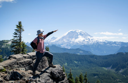 Man raising hand towards Mount Rainier from Summit Lake Trail. Mt Rainier National Park. Washington State.の写真素材