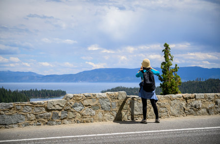 Woman taking photos using smartphone at Emerald Bay. Lake Tahoe. California.の写真素材