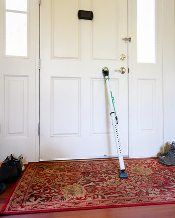 Door security bar against a white front door. View from inside the home with shoes on the side of the door. Vertical format.の写真素材