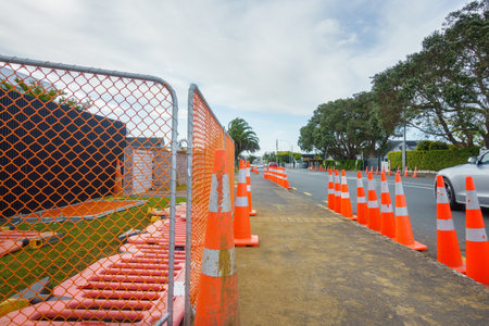 Orange traffic cones lining up the street. Cars driving on the road. Roadworks in Auckland.の写真素材