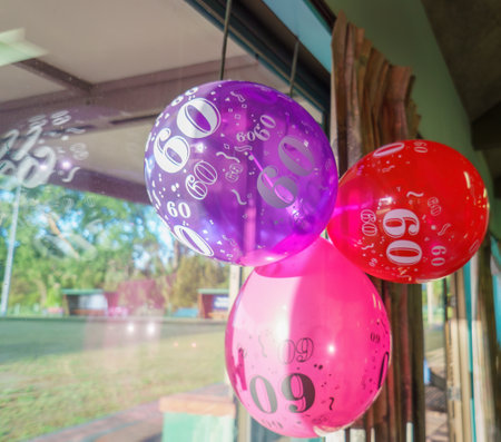 60th birthday balloons hanging from the window. Birthday celebration.の写真素材