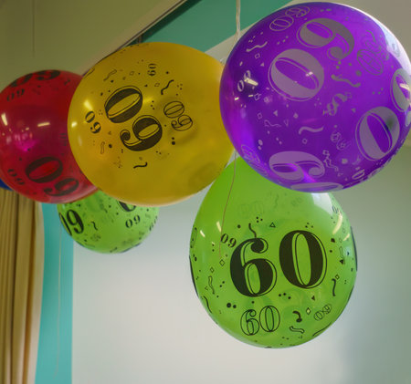 Colorful 60th birthday balloons hanging from the ceiling. Birthday celebration.の写真素材