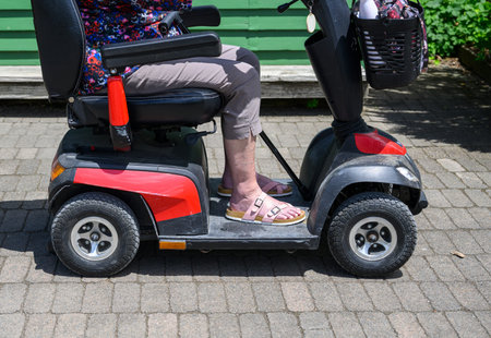 Senior woman riding a mobility scooter in the garden