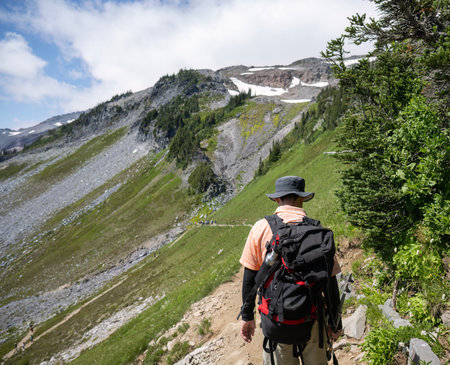 Man hiking the rugged hills at Skyline Trail. Mt Rainier National Park. Washington State.の写真素材