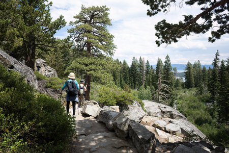 Couple hiking Eagle Lake trail. Emerald Bay in the distance. South Lake Tahoe. California.の写真素材
