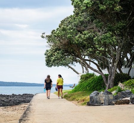 Women walking on Milford Beach. Auckland.の写真素材