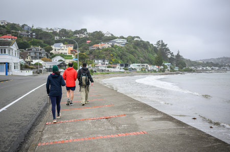 People walking on Plimmerton beach on a cold windy day. Wellington.の写真素材