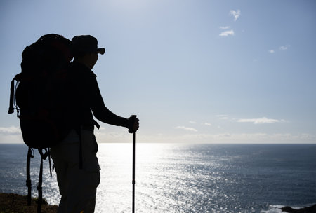 Back view of a backpacker in silhouette. Cape Brett Walkway. Bay of Islands.の写真素材