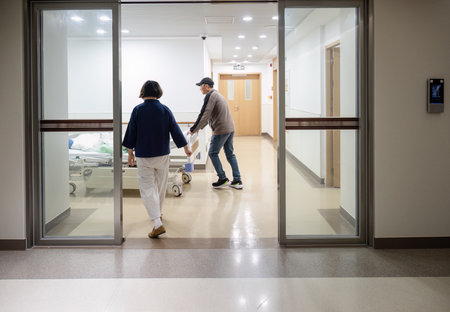 Family members helping to push patient lying in bed in a corridor at the hospital.の写真素材