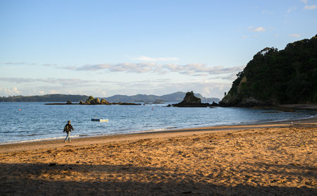 Man walking on Tapeka Point beach. Russell. Bay of Islands.の写真素材