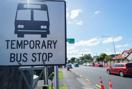 Temporary Bus Stop sign by the road. Cars travelling on the road. Roadworks in Auckland.の写真素材