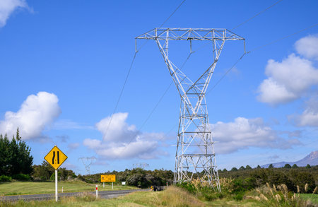 Power pylons and power lines along Desert Road. Ice road sign on the side of the road. North Island. New Zealand.の写真素材