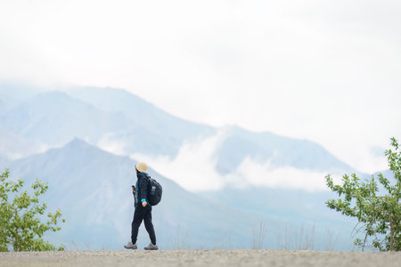 Woman hiking Denali National Park and Preserve. Cloud drifting around the high mountains. Alaska. USA.の写真素材