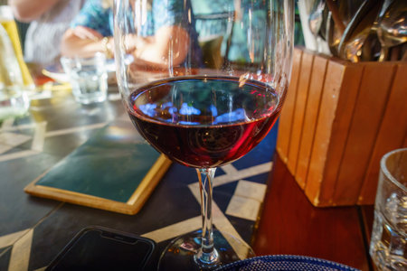 Red wine glass in a restaurant. Unrecognizable people in the background. Auckland.の写真素材